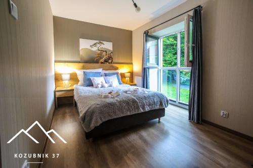 1 dormitorio con cama y ventana grande en Kozubnik 37, en Porąbka