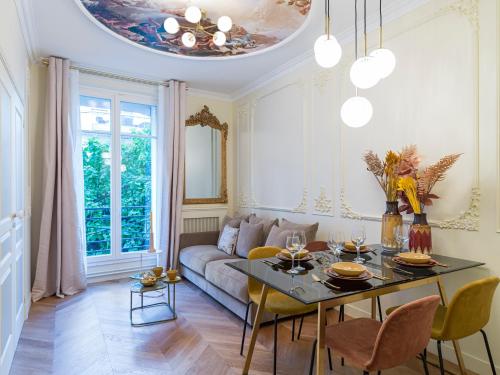 un salon avec un canapé et une table dans l'établissement The Gatsby Suite, à Paris