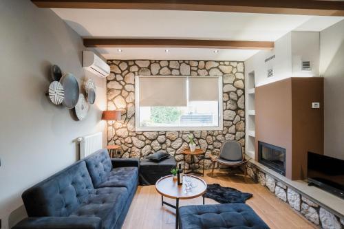 a living room with a stone wall at Meteora vibes in Kalabaka