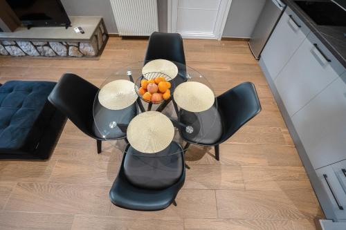 a table with chairs and a bowl of oranges on it at Meteora vibes in Kalabaka
