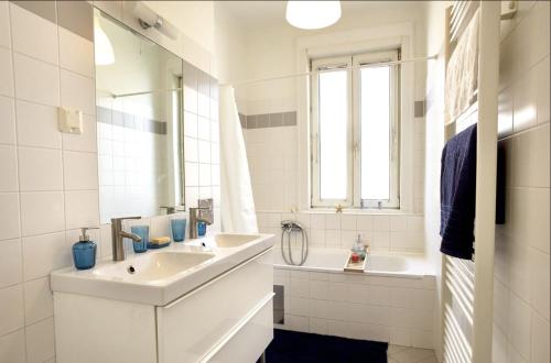 a white bathroom with a sink and a mirror at Operastreet City Center Santorin in Vienna