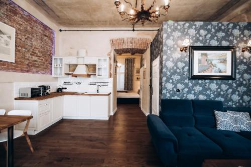 ein Wohnzimmer mit einem blauen Sofa und einer Küche in der Unterkunft Native Apartments Dunajewskiego 2 in Krakau