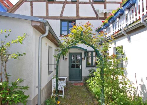ヴァーレンにあるFerienwohnungen Waren SEE 5360の緑の扉と植物のある白い家