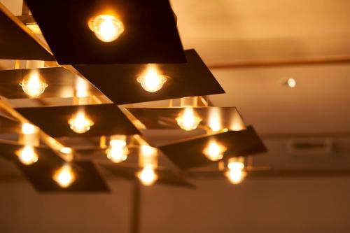 a bunch of lights hanging from a ceiling at Tassel Inn Kyoto Kawaramachi Nijo in Kyoto