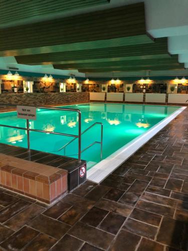 a large swimming pool in a hotel with a blue water at Mariposa 4 incl Pool & Sauna in Bad Harzburg