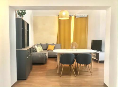 un salon avec une table, des chaises et un canapé dans l'établissement T2 Rénové, moderne et cozy - Centre Historique, à Montpellier