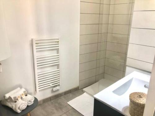 une salle de bain blanche avec un lavabo et une douche dans l'établissement T2 Rénové, moderne et cozy - Centre Historique, à Montpellier