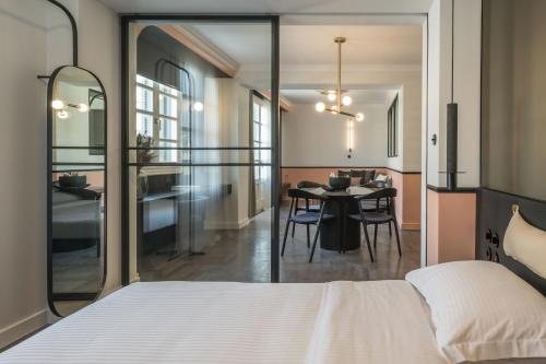 72 AD Suites في سلانيك: غرفة نوم مع سرير وغرفة طعام