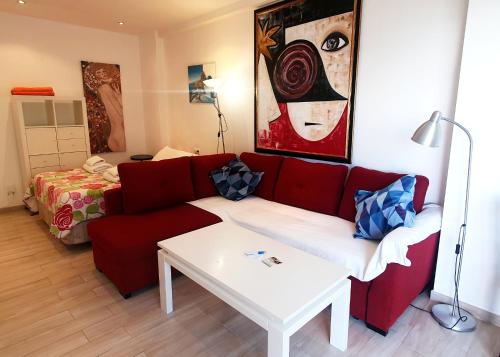 - un salon avec un canapé rouge et une table dans l'établissement Skol 219. Studio Apartment Skol Marbella with Sea Views, à Marbella