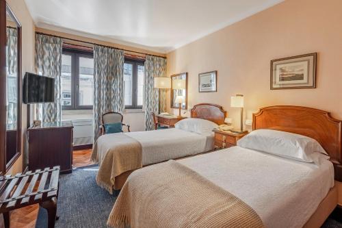 a hotel room with two beds and a television at Hotel Lisboa Plaza - Lisbon Heritage Collection - Avenida in Lisbon