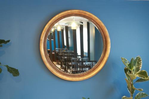 uno specchio appeso a una parete blu di Orly Superior Hotel ad Athis-Mons