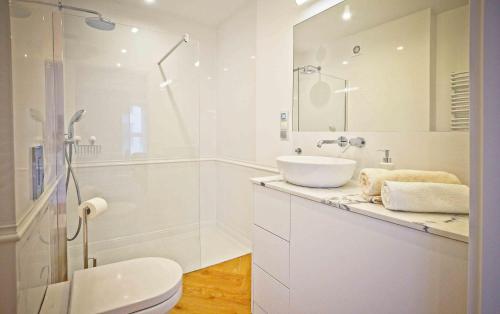 a white bathroom with a sink and a shower at Elegant Apartment Oldtown Marina in Gdańsk