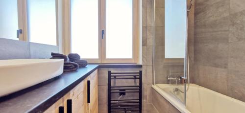 een badkamer met een wastafel en een bad bij Appartement Chalet Montjoye in Saint-Gervais-les-Bains