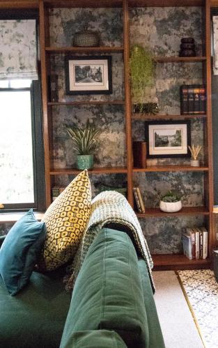 a living room with a green couch with pillows at Wuthering Heights in Sedbergh