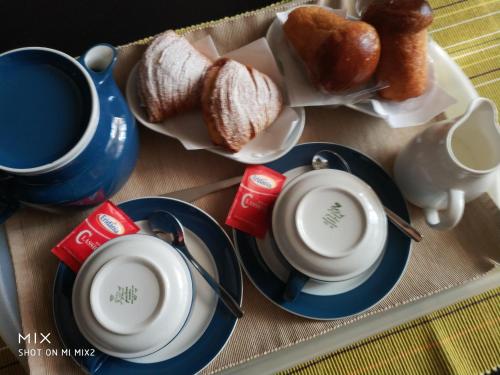 un tavolo ricoperto di tazze, piattini e pane di B&B Baggere a Napoli