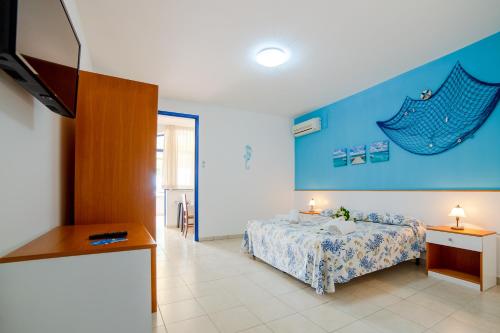 a bedroom with a bed and a flat screen tv at Scialabà Residence Salento in Torre Pali 