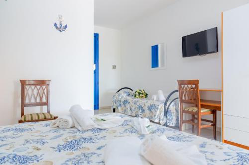 a room with a bed and a table with towels at Scialabà Residence Salento in Torre Pali 