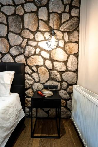 a bedroom with a table next to a stone wall at Meteora vibes in Kalabaka