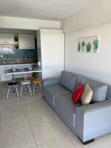 a living room with a couch and a kitchen at Flats de 2 Quartos no Ancorar in Porto De Galinhas