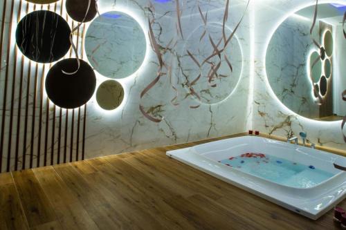 a bathroom with a tub and mirrors on the wall at B&B Villa Grace in Bari