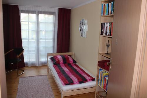 a bedroom with a bed and a book shelf at Bärchenhof in Priestewitz