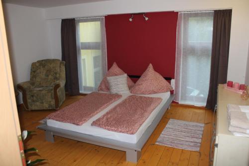 1 dormitorio con 1 cama, 1 silla y ventanas en Bärchenhof en Priestewitz