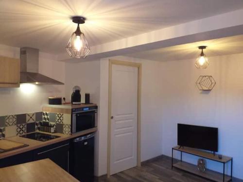 una cucina con un soffitto con due luci e una porta di Nuit romantique a Saint-Christophe-en-Brionnais