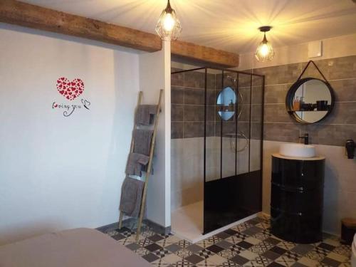 una camera da letto con bagno con doccia e specchio di Nuit romantique a Saint-Christophe-en-Brionnais