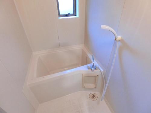 a white bath tub in a bathroom with a window at Hotel Futaba Heights -フタバハイツ- in Tokyo