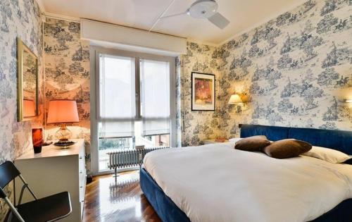 una camera con un grande letto e una finestra di Carlo Poma a Milano