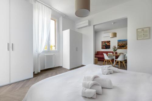 una camera bianca con un grande letto bianco e mobili bianchi di Palazzo Pedretti Halldis Apartments a Bologna