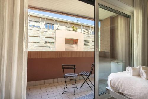 ein Schlafzimmer mit einem Bett und einem Stuhl auf dem Balkon in der Unterkunft Pastorelli - appartamento sui Navigli con posto auto in Mailand