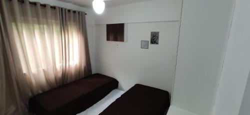Habitación pequeña con cama y ventana en Porto Real Suítes Mangaratiba, en Mangaratiba