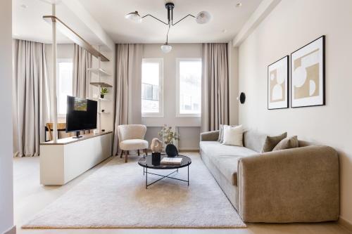 a living room with a couch and a tv at Luxury Apartments in Plaka by UPSTREET in Athens