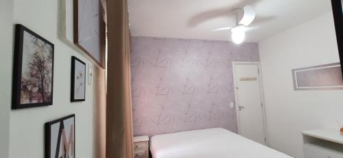 a bedroom with a bed and a pink wall at Porto Real Suítes Mangaratiba in Mangaratiba