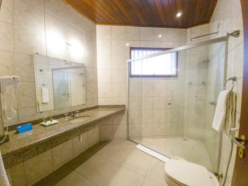 a bathroom with a shower and a toilet and a sink at Beach Hotel Maresias in Maresias