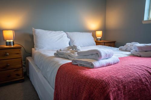 a bedroom with a bed with towels on it at The Farmhouse, 6 bed property, Forres in Forres