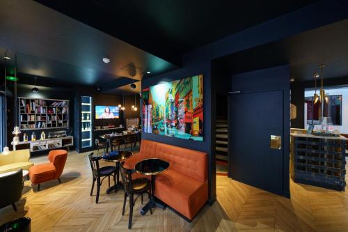 un bar avec des chaises et des tables dans un restaurant dans l'établissement Hotel Scarlett, à Paris