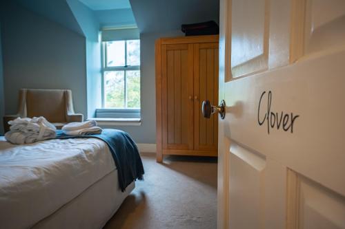 a bedroom with a bed and a window and a door at The Farmhouse, 6 bed property, Forres in Forres