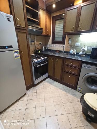 a kitchen with a refrigerator and a dishwasher at شقةفاخرةبجليم على البحر مباشرة in Alexandria