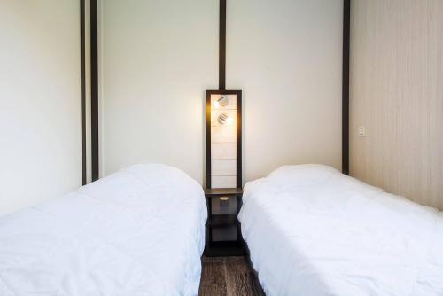 two beds sitting next to each other in a bedroom at Dives-sur-Mer le Conquérant in Dives-sur-Mer