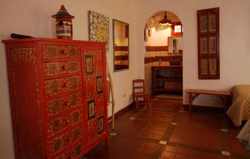 a room with a red dresser and a bedroom at El Pueblito Hotel Boutique in Samaipata