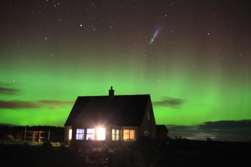 a house with the green northern lights in the sky at Alba Sunrise in Keiss