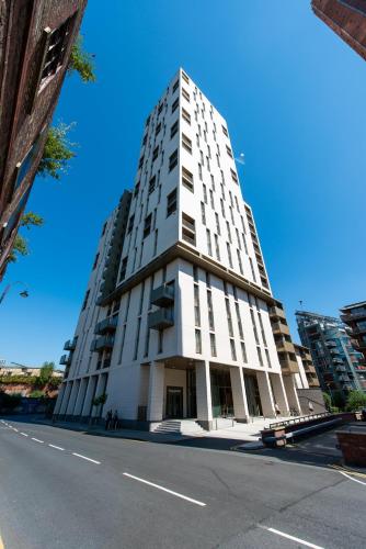 a tall white building on the side of a street at The Assembly Manchester Oasis Holding in Manchester