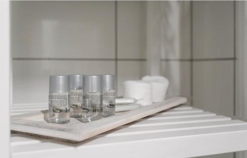 uma prateleira numa casa de banho com três garrafas e toalhas em Studio-Apartment between Schoenbrunn & the City Center (18) em Viena