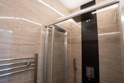 um chuveiro com uma porta de vidro na casa de banho em The Hop Inn em Bournemouth