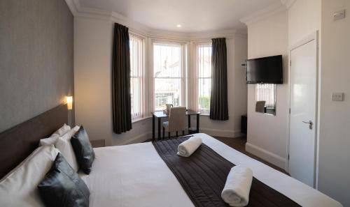 a hotel room with a large bed and a table at The Hop Inn in Bournemouth