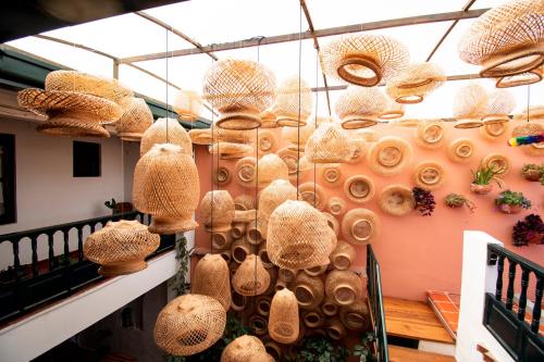 a bunch of baskets hanging on a wall at Sie Casa Hotel in Villa de Leyva