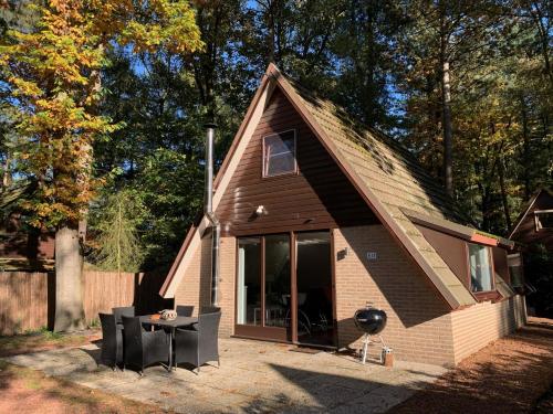 a small house with a table and chairs in front of it at Natuurhuis 'Van De Wereld' in Lanaken