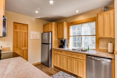 a kitchen with wooden cabinets and a stainless steel refrigerator at Eagle Crest Family Friendly Chalet in Redmond